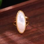 A single stainless steel ring from the collection, featuring a white gold oval ring, naturally iridescent, inlaid with white pearl and resin, luxurious accessories in a French vintage style. The open design is adjustable and does not fade, with a simple and refined design in two styles. - Bezenia's